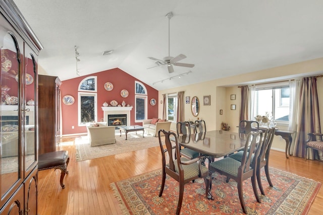 dining area with vaulted ceiling, ceiling fan, and light wood-type flooring