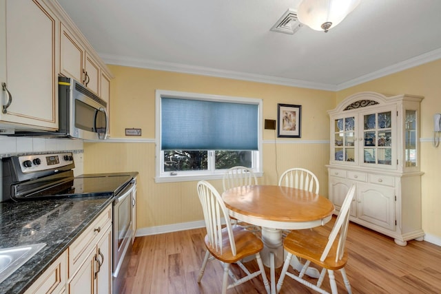 dining space with ornamental molding and light wood-type flooring