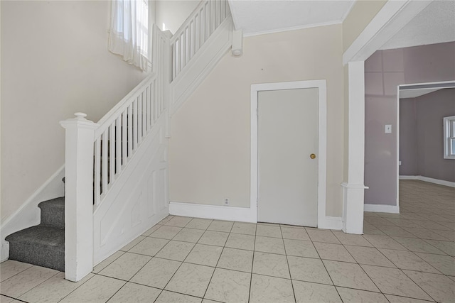 stairs with tile patterned flooring and ornamental molding