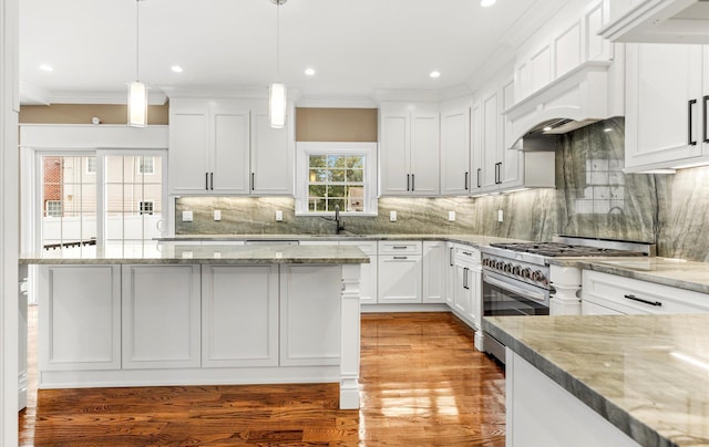 kitchen featuring backsplash, white cabinets, high end range, hanging light fixtures, and light stone countertops