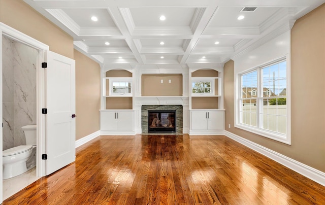 unfurnished living room featuring coffered ceiling, a fireplace, wood-type flooring, and beam ceiling