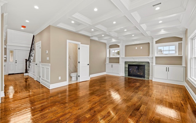 unfurnished living room with wood-type flooring, coffered ceiling, a high end fireplace, and beam ceiling