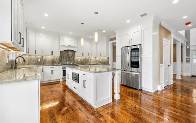 kitchen featuring sink, a kitchen island, pendant lighting, stainless steel appliances, and white cabinets