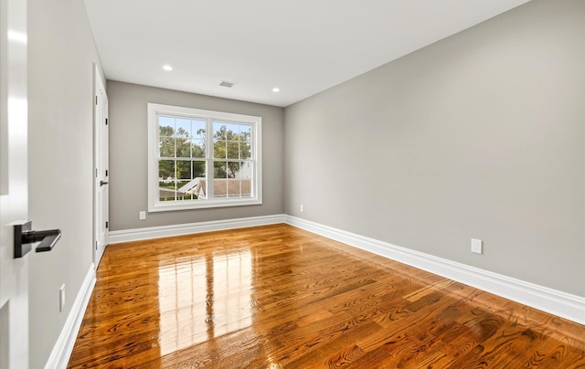 unfurnished room with hardwood / wood-style flooring