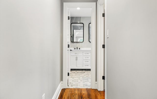 corridor featuring sink and hardwood / wood-style floors