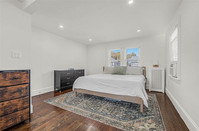 bedroom with radiator heating unit and dark hardwood / wood-style flooring