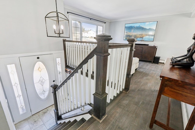 entrance foyer featuring a baseboard radiator, ornamental molding, a chandelier, and wood-type flooring