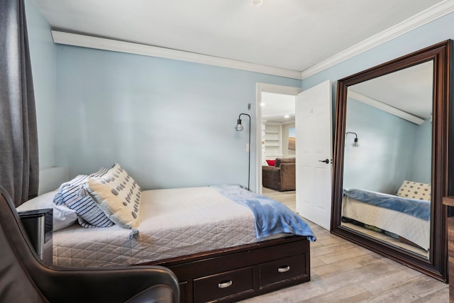 bedroom with ornamental molding and light wood-type flooring