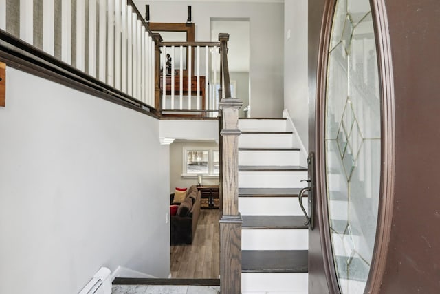 stairs with a high ceiling and a baseboard heating unit