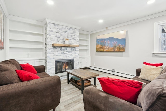 living room with a stone fireplace, ornamental molding, baseboard heating, light wood-type flooring, and built in shelves