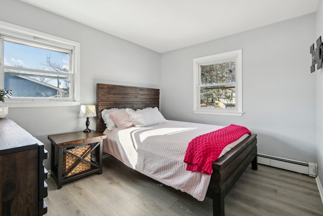 bedroom with hardwood / wood-style flooring and a baseboard radiator