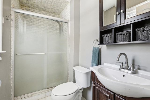 bathroom featuring vanity, an enclosed shower, and toilet