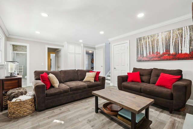 living room with ornamental molding and light hardwood / wood-style floors