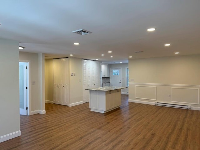 kitchen featuring dark hardwood / wood-style flooring, a kitchen island, white cabinets, and baseboard heating