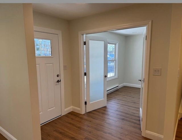 foyer featuring baseboard heating and dark hardwood / wood-style floors