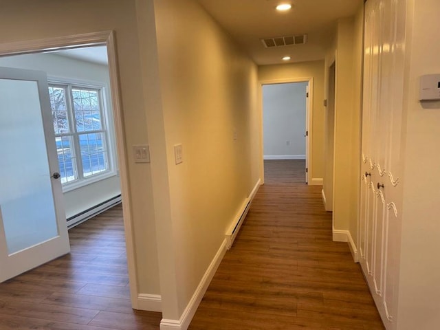 hallway featuring baseboard heating and dark hardwood / wood-style floors