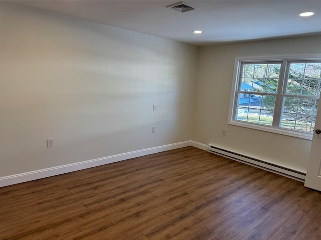 empty room featuring dark hardwood / wood-style flooring and baseboard heating