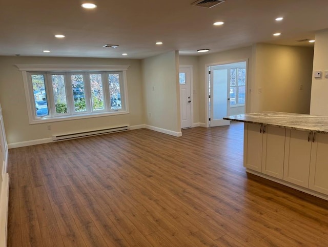 interior space featuring baseboard heating and dark wood-type flooring