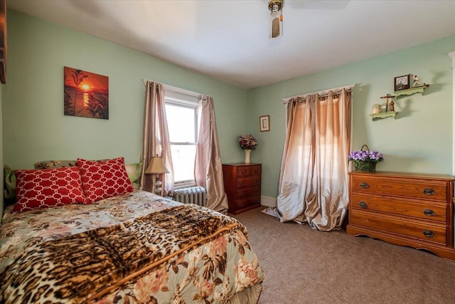 carpeted bedroom featuring ceiling fan and radiator heating unit