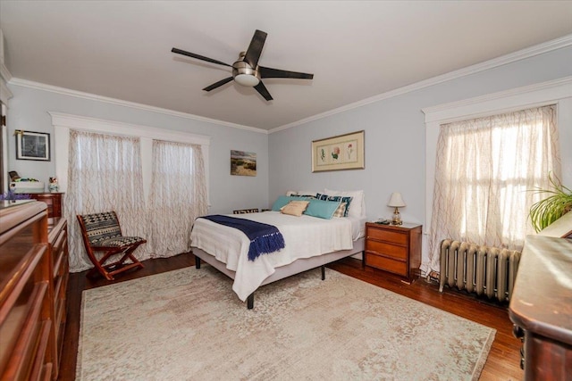 bedroom with dark wood-type flooring, ceiling fan, crown molding, and radiator