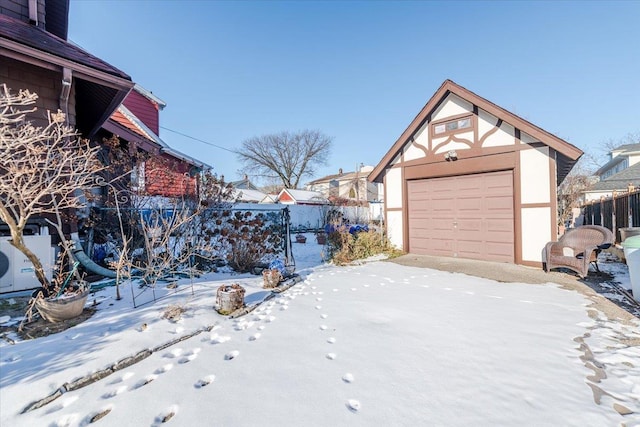 yard covered in snow with an outbuilding and a garage