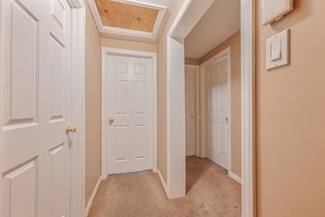 hallway featuring ornamental molding and light colored carpet