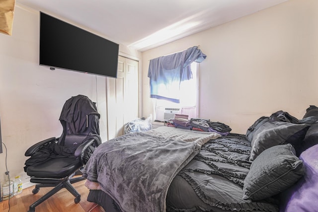 bedroom featuring cooling unit, hardwood / wood-style floors, and a closet