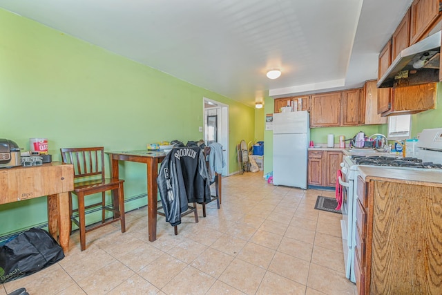 kitchen featuring light tile patterned flooring and white appliances