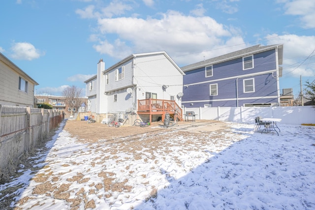 snow covered rear of property featuring a deck