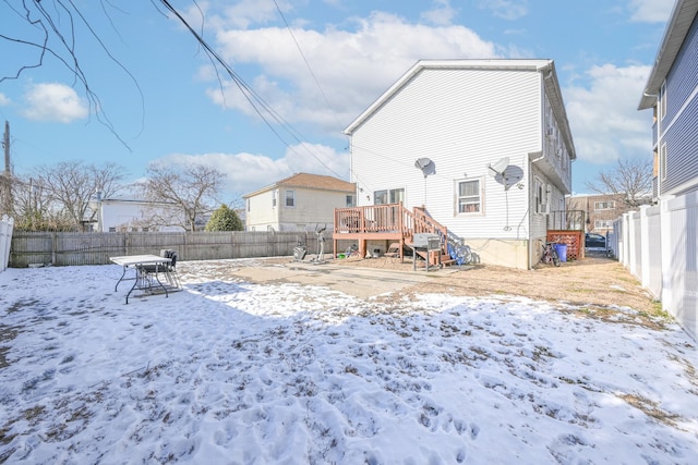 snow covered rear of property featuring a deck