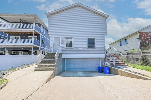20 E Pine St, Long Beach, NY 11561 - back of house featuring a garage, concrete driveway, and stairway
