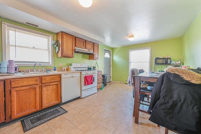 20 E Pine St, Long Beach, NY 11561 - kitchen featuring white appliances, under cabinet range hood, light countertops, brown cabinets, and light tile patterned flooring