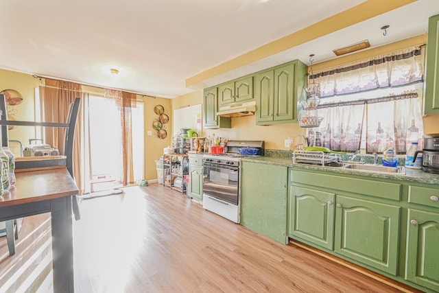 20 E Pine St, Long Beach, NY 11561 - kitchen with white range with gas stovetop, green cabinets, under cabinet range hood, and light wood-type flooring