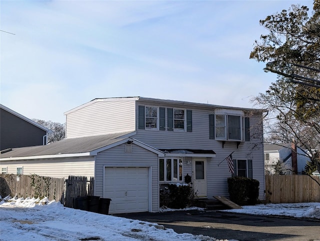 traditional home with fence and an attached garage