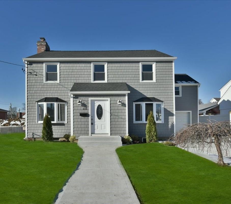 view of front of house featuring a garage and a front lawn