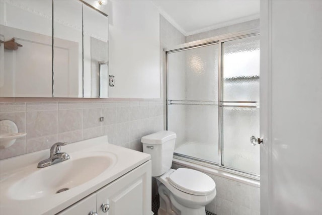 full bathroom with bath / shower combo with glass door, tasteful backsplash, tile walls, vanity, and toilet