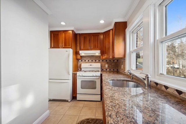 kitchen with sink, crown molding, light tile patterned floors, white appliances, and light stone countertops