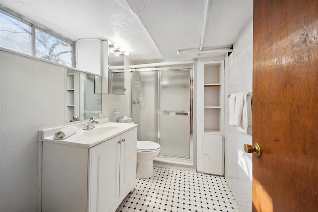 bathroom featuring an enclosed shower, vanity, a textured ceiling, and toilet