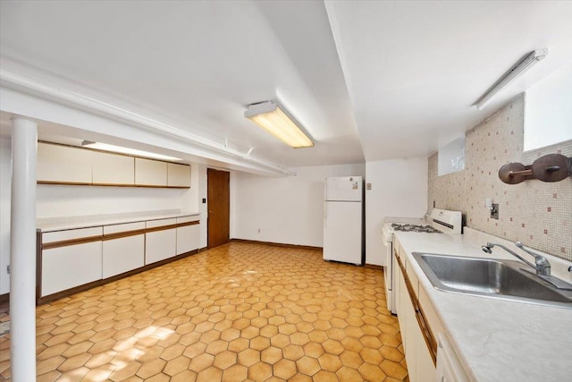 kitchen featuring white cabinetry, white appliances, brick wall, and sink