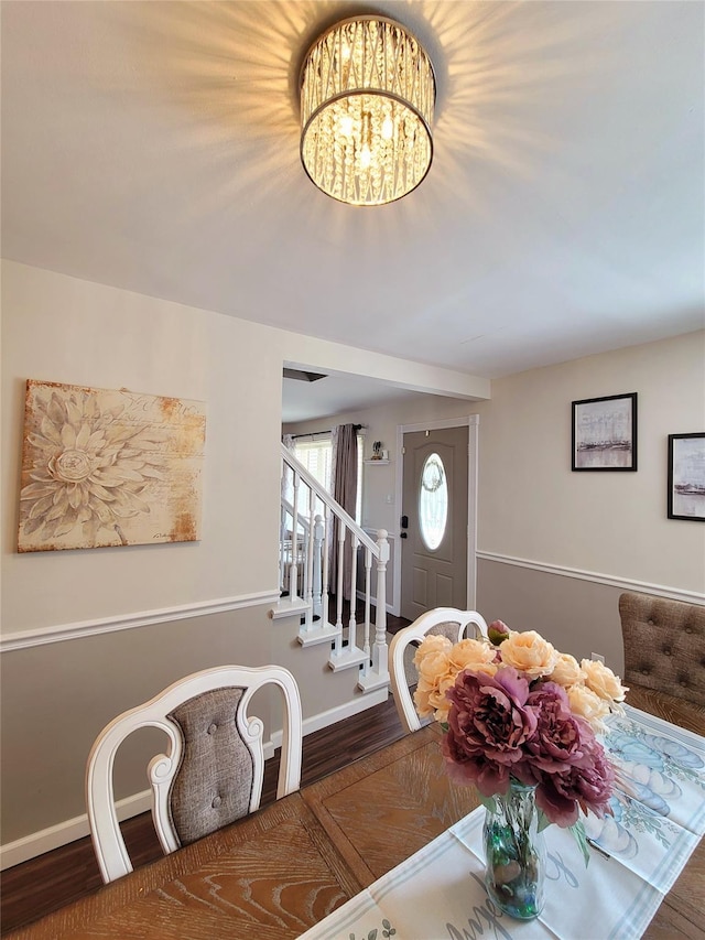 dining area with hardwood / wood-style flooring and a chandelier