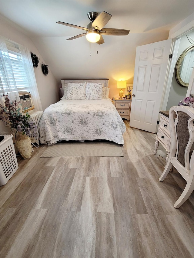 bedroom featuring cooling unit, ceiling fan, vaulted ceiling, and light wood-type flooring