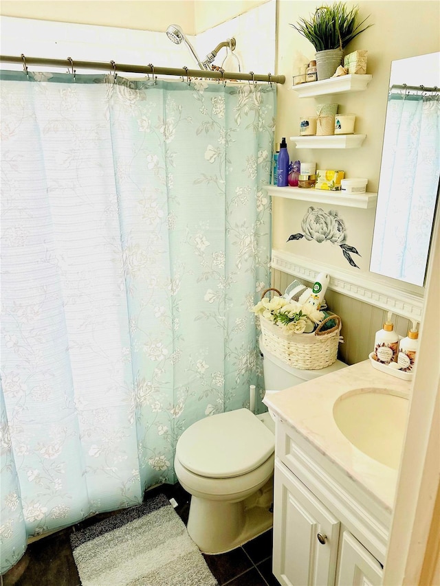 bathroom featuring vanity, tile patterned floors, and toilet