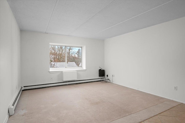 carpeted spare room with a baseboard radiator and a textured ceiling