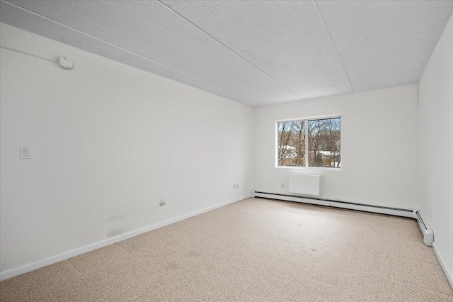 spare room with carpet, a baseboard heating unit, and a textured ceiling