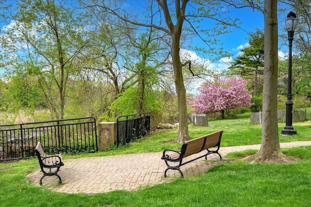 view of property's community with a patio area and a lawn