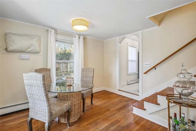 dining room featuring a baseboard heating unit and hardwood / wood-style floors