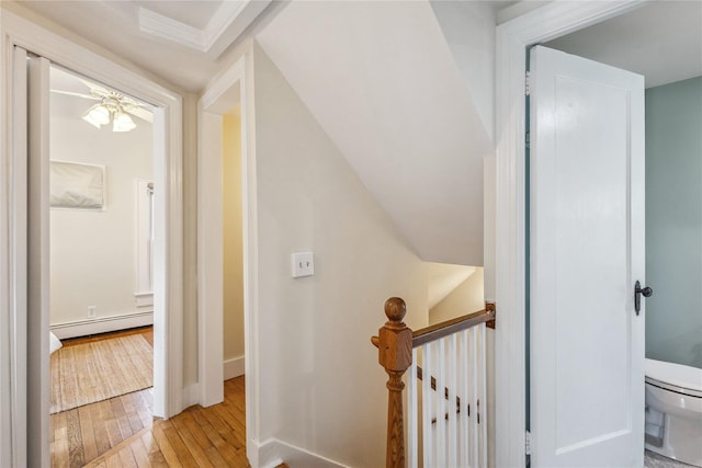 hall with lofted ceiling, a baseboard heating unit, and light wood-type flooring