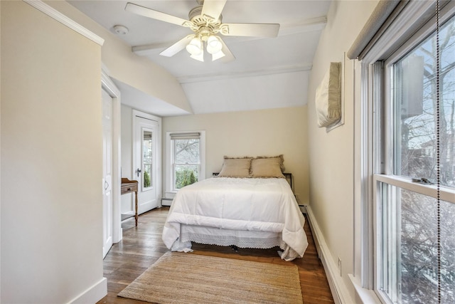 bedroom featuring baseboard heating, dark wood-type flooring, ceiling fan, and vaulted ceiling