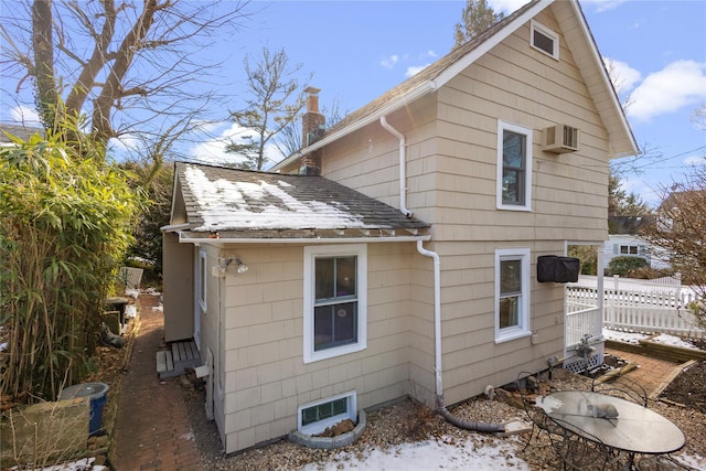 back of property featuring an AC wall unit