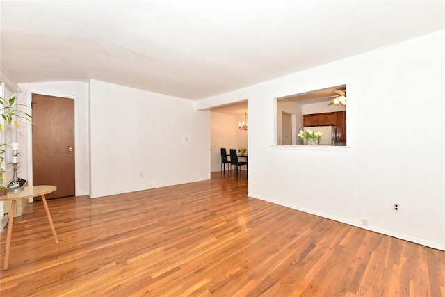 empty room with a chandelier and light hardwood / wood-style floors